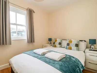 two beds in a bedroom with a window at Fox's Retreat in Keswick