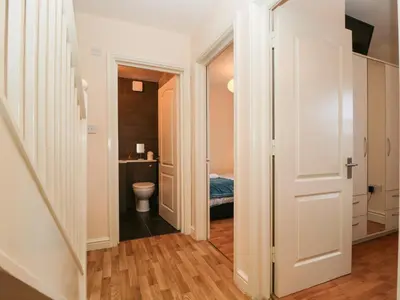 a corridor of a bathroom with a toilet and a sink at Fox's Retreat in Keswick