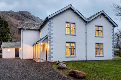 a white house with a mountain in the background at The Vicarage in Keswick
