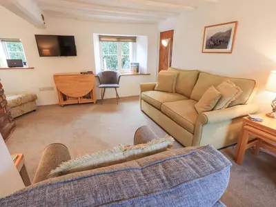 a living room with a couch and a table at Jacky Garth Cottage in Keswick