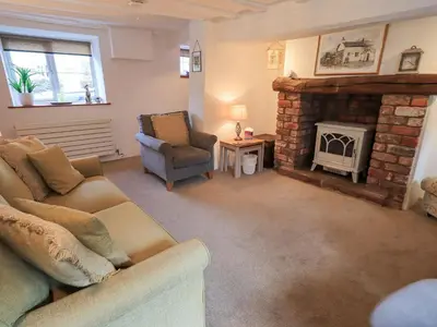 a living room with a couch and a fireplace at Jacky Garth Cottage in Keswick