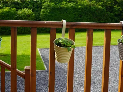 a potted plant is hanging on a railing at Roe Deer Lodge in Newton Stewart