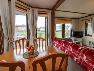 a living room with a table and a couch at Roe Deer Lodge in Newton Stewart