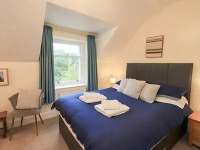 a bedroom with a blue bed with towels on it at Hazelmere in Keswick