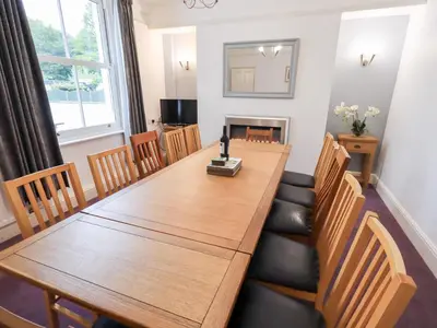 a dining room with a long wooden table and chairs at Hazelmere in Keswick