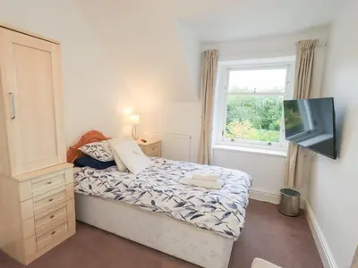 a small bedroom with a bed and a window at Hazelmere in Keswick