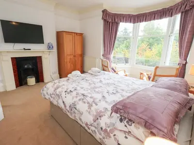 a bedroom with a bed and a tv and a fireplace at Hazelmere in Keswick