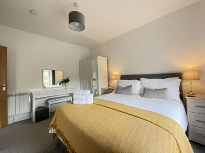 a bedroom with a large bed and a desk at Skiddaw View in Keswick