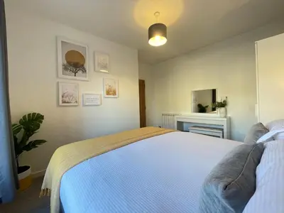 a bedroom with a white bed and a mirror at Skiddaw View in Keswick
