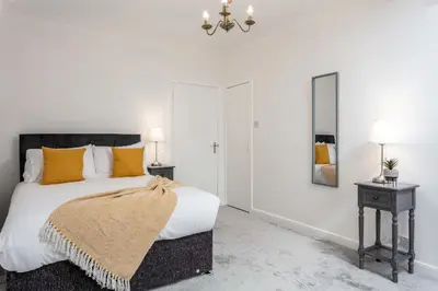 a bedroom with a large bed and a mirror at Wellington View - Donnini Apartments in Ayr