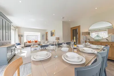 a dining room and living room with a table and chairs at Cherry Garth HOT TUB HIRE AVAILABLE in Keswick