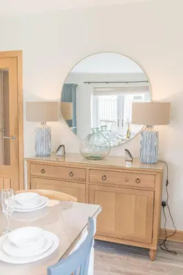 a dining room with a table and a mirror at Cherry Garth HOT TUB HIRE AVAILABLE in Keswick