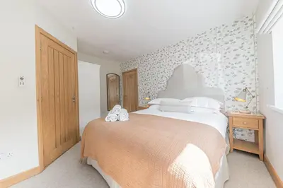 a bedroom with a large bed in a room at Cherry Garth HOT TUB HIRE AVAILABLE in Keswick