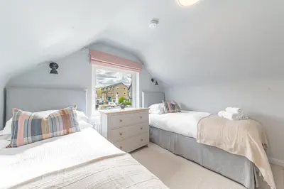 two beds in a room with a window at Cherry Garth HOT TUB HIRE AVAILABLE in Keswick