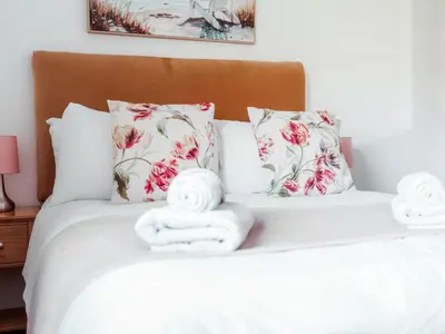 a bedroom with a bed with towels on it at Drumwherry By The Sea in Monreith