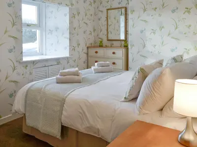 a bedroom with a large bed with a mirror on the wall at Drumwherry By The Sea in Monreith