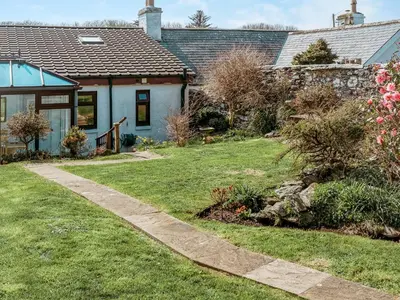 a house with a garden and a walkway at Drumwherry By The Sea in Monreith