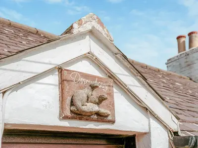 a sign on a building with a squirrel on it at Drumwherry By The Sea in Monreith