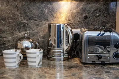 a toaster and coffee cups on a counter at Keswick Ground floor apartment with parking in Keswick