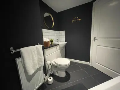 a black bathroom with a toilet and a sink at Niche View in Irvine