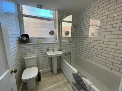 a white bathroom with a toilet and a sink at Red Gables - Ground Floor in Carlisle