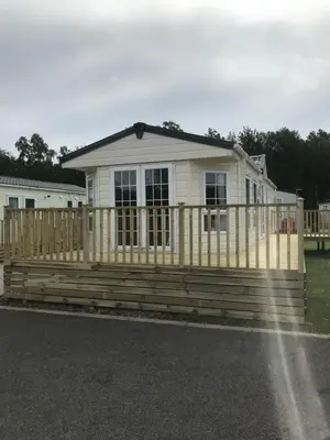 a wooden fence in front of a house at Cumbria Reach in Longtown