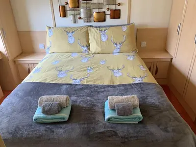 a bed with two towels on top of it at Holiday Caravan - Sleeps 4 with Parking in Whithorn