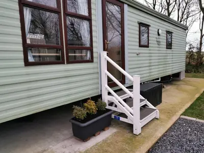 a staircase leading up to a tiny house at Holiday Caravan - Sleeps 4 with Parking in Whithorn