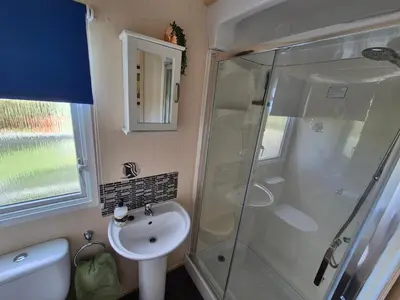 a bathroom with a shower and a sink at 24 The Beeches Caravan Park in Gilcrux