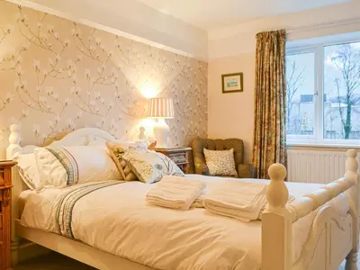 a bedroom with a white bed and a window at Parkfield in Keswick
