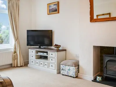 a living room with a television and a fireplace at Parkfield in Keswick