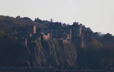 a castle sitting on top of a hill at Grand top floor apartment in the Royal Bank House in Maybole