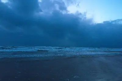 a beach with a cloudy sky and the ocean at Grand top floor apartment in the Royal Bank House in Maybole