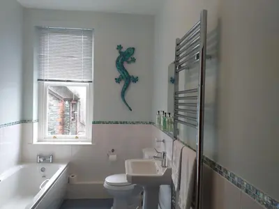 a bathroom with a sink and a toilet and a bath tub at Glencoe Guest House in Keswick