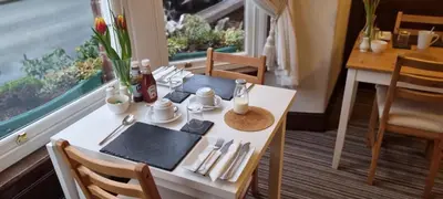 a table in a room with a table and a window at Glencoe Guest House in Keswick