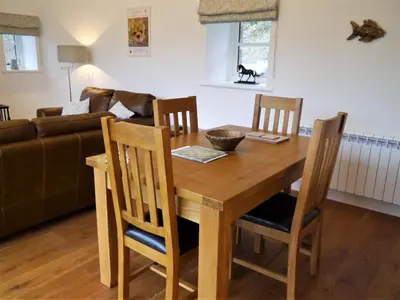 a wooden dining room table with chairs and a couch at The Fish House in Kirkcudbright