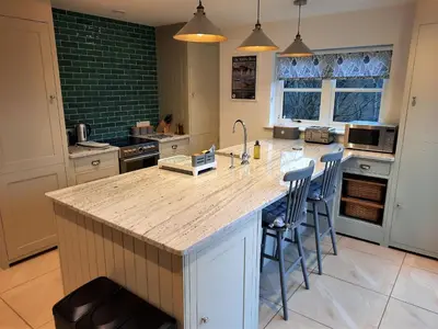 a kitchen with a large island with bar stools at The Fish House in Kirkcudbright