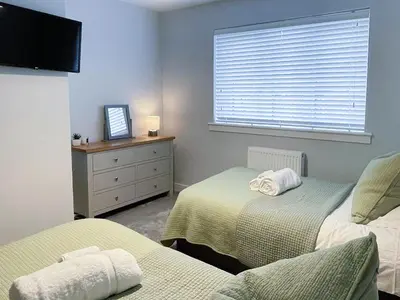 a bedroom with two beds and a dresser and a window at 4 Mote View-Uk37497 in Sandhead