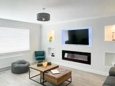 a living room with a fireplace and a tv at 4 Mote View-Uk37497 in Sandhead