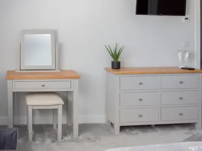 a dresser with a mirror and a desk with a chair at 2 Mote View- Uk37496 in Sandhead