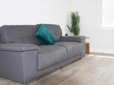 a gray couch with a blue pillow in a living room at 2 Mote View- Uk37496 in Sandhead
