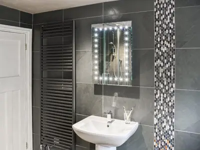 a bathroom with a sink and a mirror at Forge Cottage in Keswick