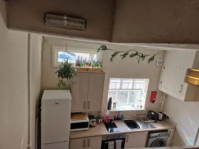 a small kitchen with a white refrigerator and a window at Carlisle Central, Cute Studio Appt, The Cupboard in Carlisle
