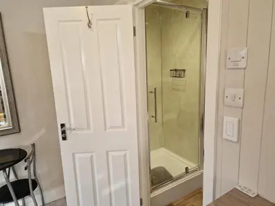 a bathroom with a shower with a glass door at Carlisle Central, Cute Studio Appt, The Cupboard in Carlisle