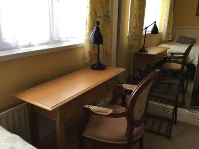 a room with a desk and two chairs and a bed at Strawberry Fields in Cockermouth
