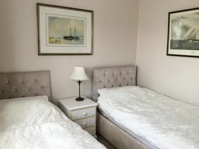 a bedroom with two beds and a lamp on a night stand at Strawberry Fields in Cockermouth