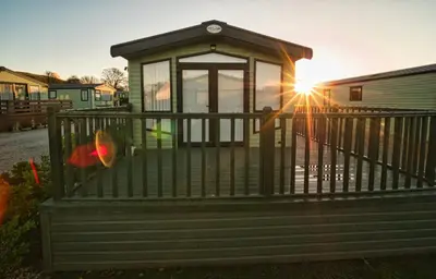 a person standing on a porch with the sun in the background at Bayfield in Lamplugh