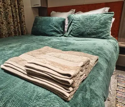 a pile of towels sitting on top of a bed at Bayfield in Lamplugh