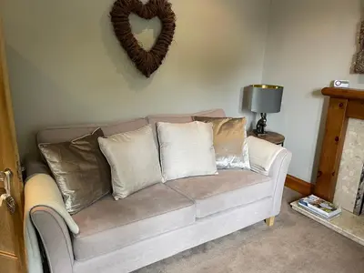 a couch with pillows and a heart on the wall at River View in Dumfries