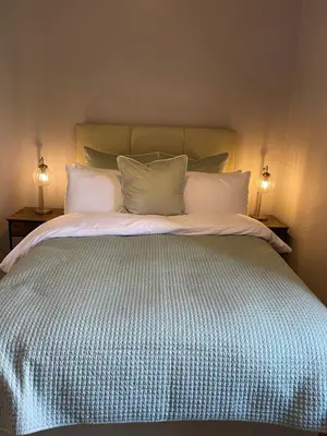 a large bed with white pillows and two lamps at River View in Dumfries